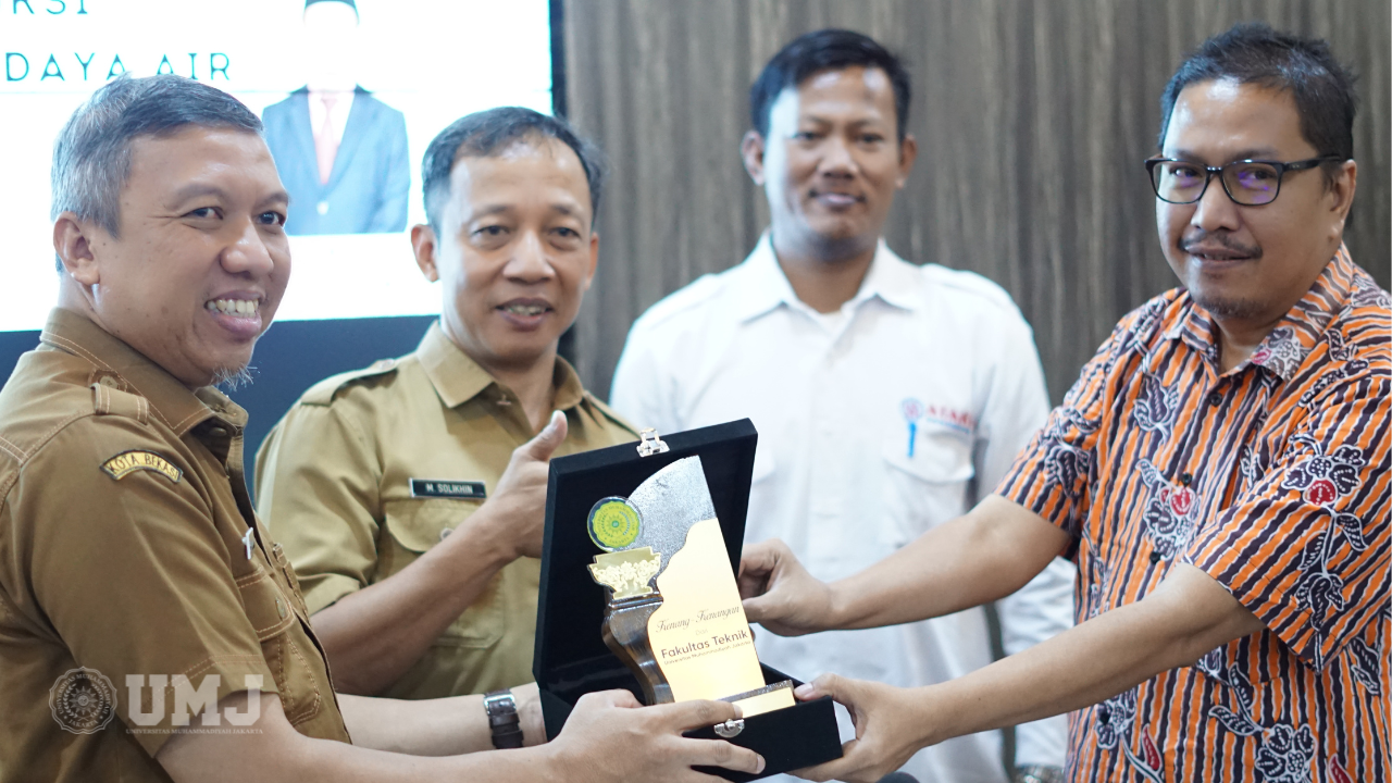 Dosen Prodi Teknik Sipil FT UMJ Dr. Mohammad Imamuddin, S.T., M.T. (kanan) saat menyerahkan plakat kenang-kenangan ke Dinas BMSDA Kota Bekasi di Gedung Sumber Daya Air Kota Bekasi, Selasa (24/10/2023).