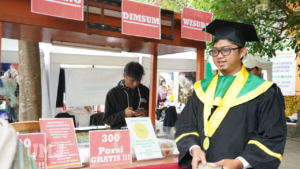 Adonis Wisudawan Program Studi Ilmu Kesejahteraan Sosial Saat Bagikan Dimsum Gratis di Wisuda UMJ, Hari Selasa (21/11/23).